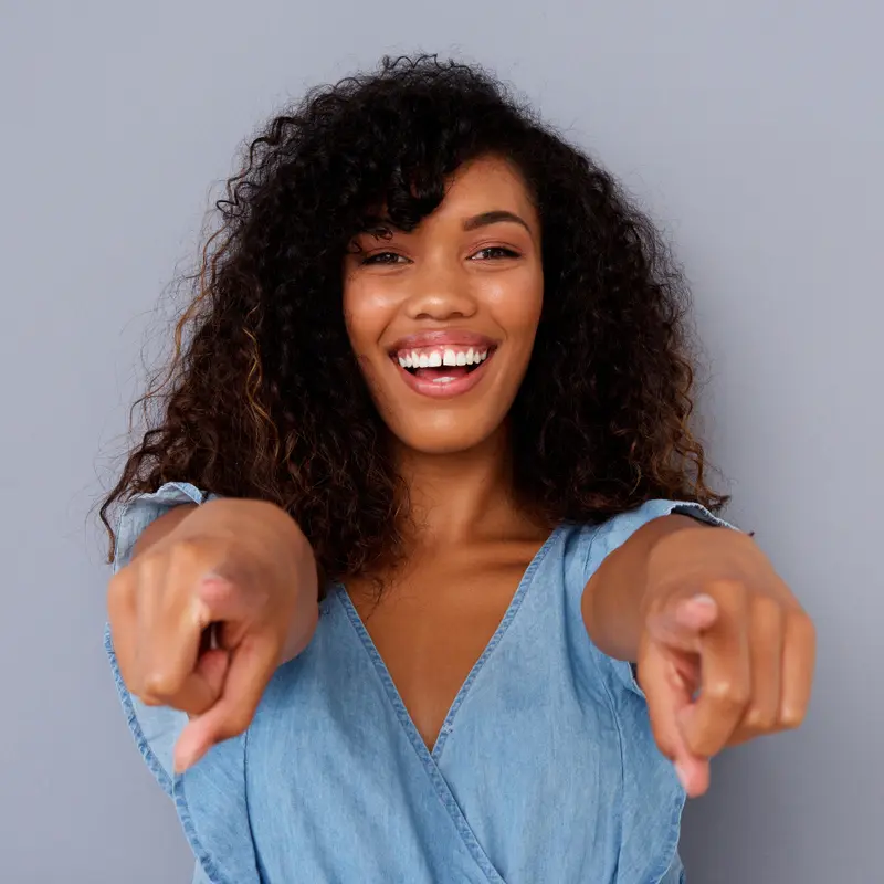 Smiling woman pointing at the camera